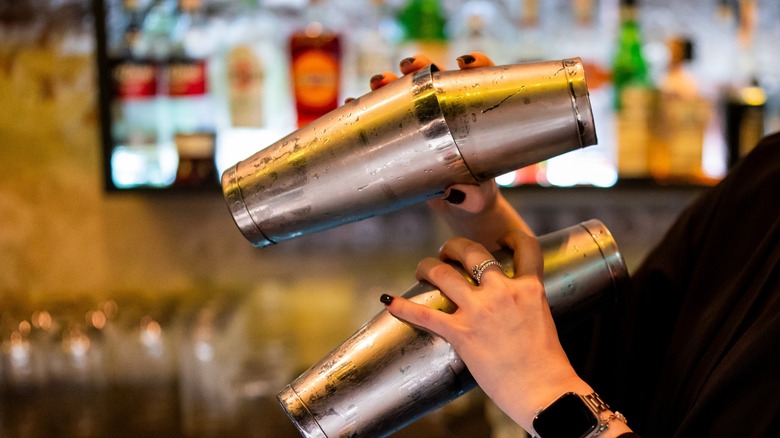 a bartender's hands shake cocktail mixers