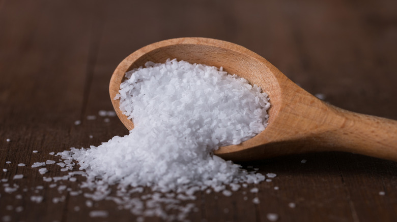 Salt spilling from a wooden spoon