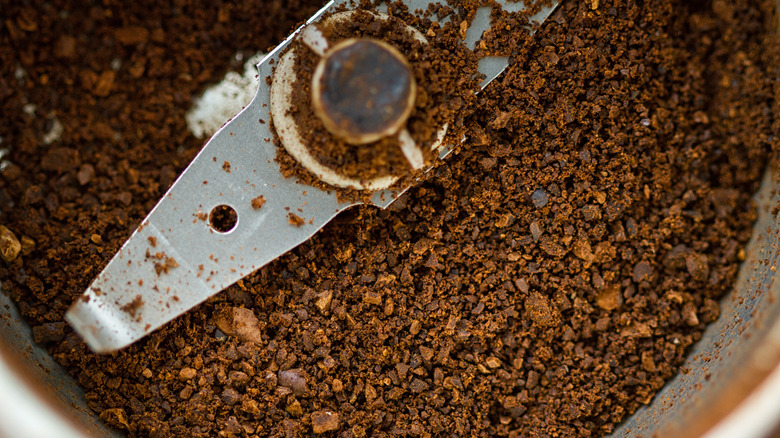 Close-up of coffee grinder blade and grounds