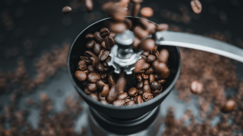 Coffee beans pouring into grinder