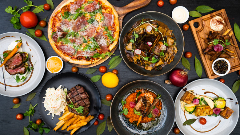 Different colored foods on a dark surface with colorful accompaniments
