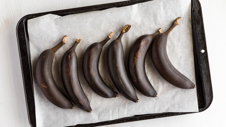 blackened bananas on a baking sheet lined with parchment paper
