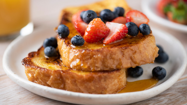 French toast with berries and honey on plate