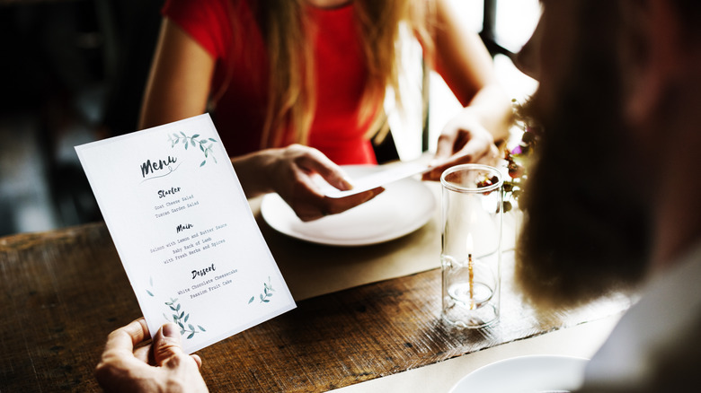 people reading off menu at restaurant