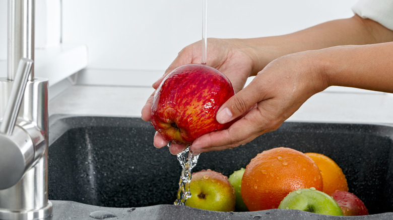 Apple being held and washed